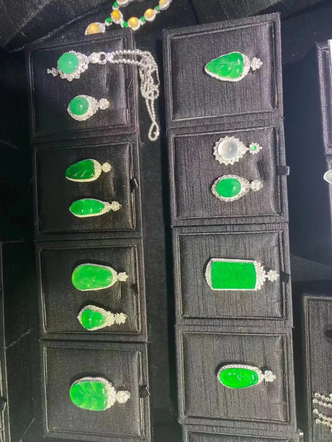 Jade jewelry displayed on black trays