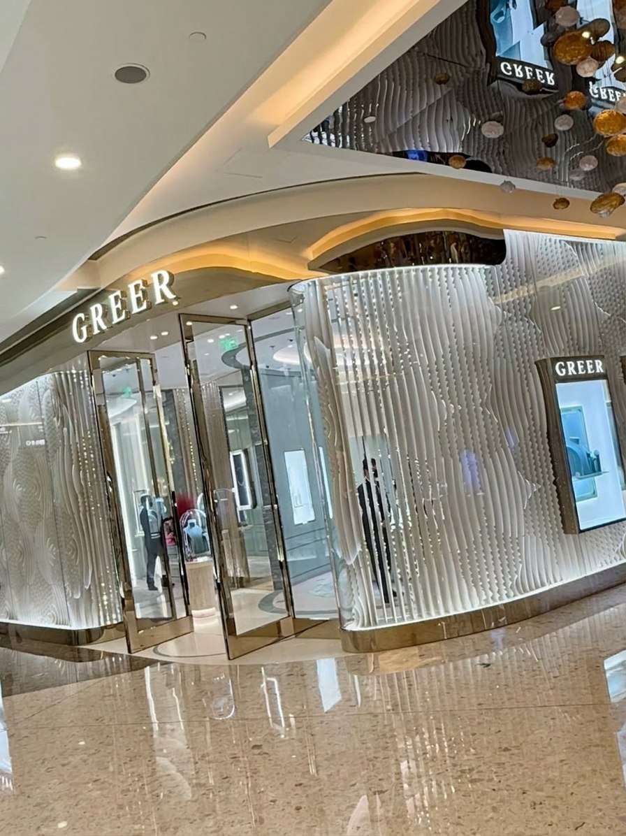 GREER boutique entrance with curved illuminated glass walls