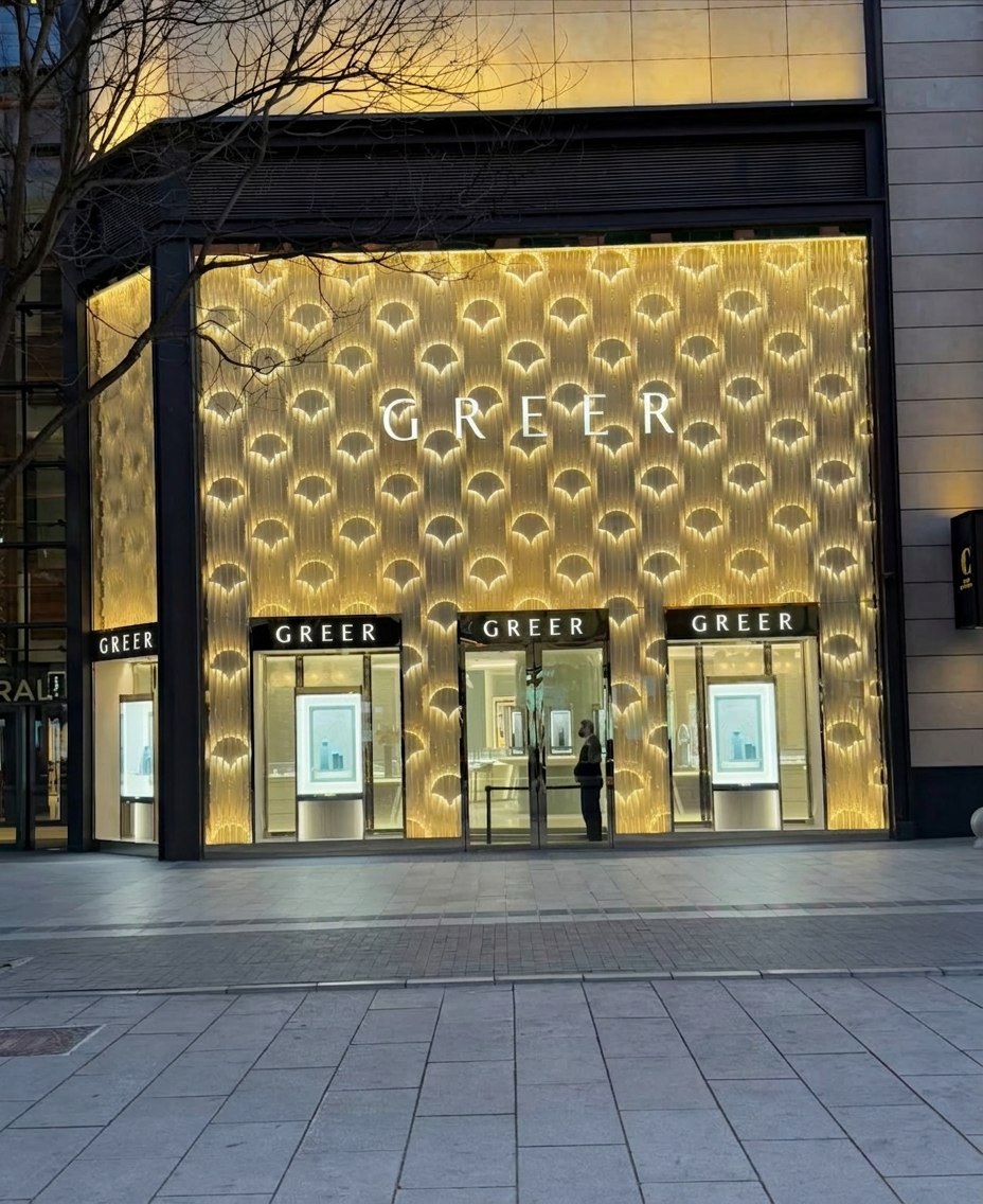 GREER jewelry storefront with golden illuminated facade
